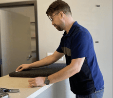 Man showing how to mount an S2224 Sorber sound absorption panel to a wall with Velcro
