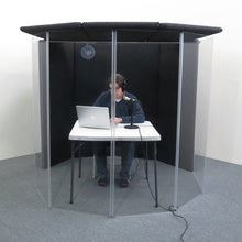 A podcaster recording a podcast inside an IsoPac I isolation booth.
